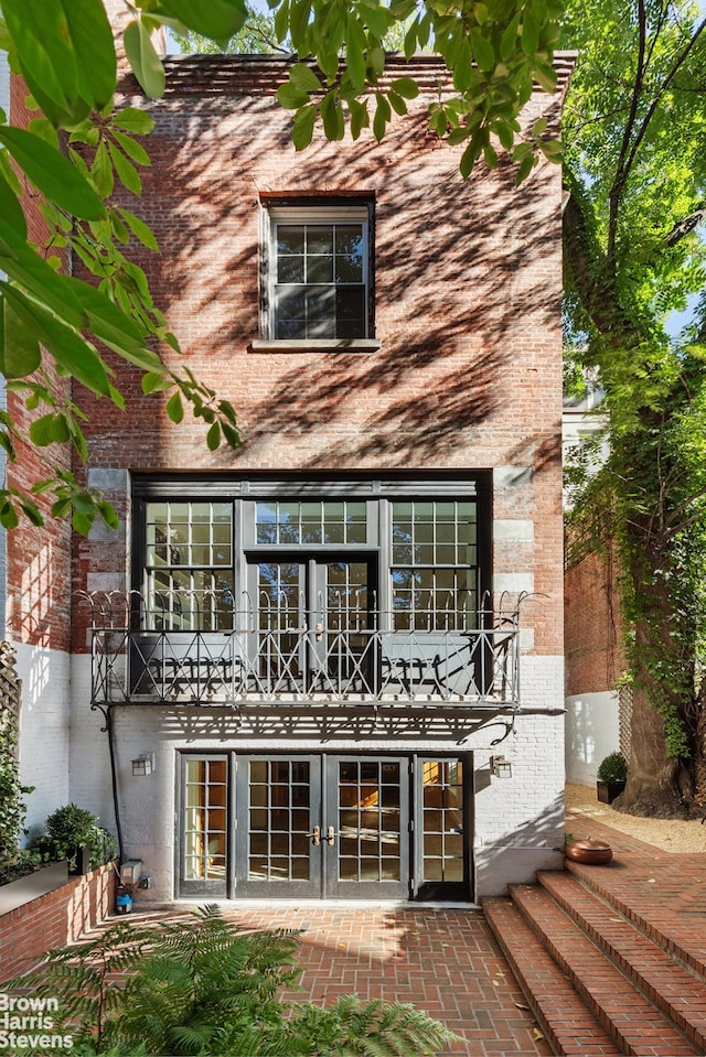 back of property featuring french doors and brick siding