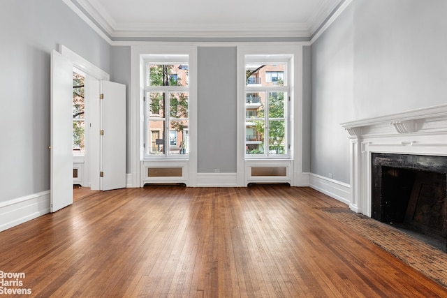 unfurnished living room featuring a high end fireplace, baseboards, crown molding, and hardwood / wood-style flooring