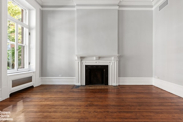 unfurnished living room featuring a fireplace with flush hearth, crown molding, baseboards, and wood finished floors