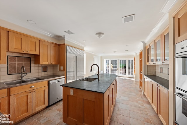 kitchen with a sink, visible vents, dark countertops, and appliances with stainless steel finishes