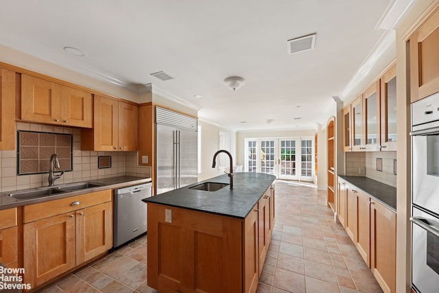 kitchen with a sink, dark countertops, appliances with stainless steel finishes, and visible vents
