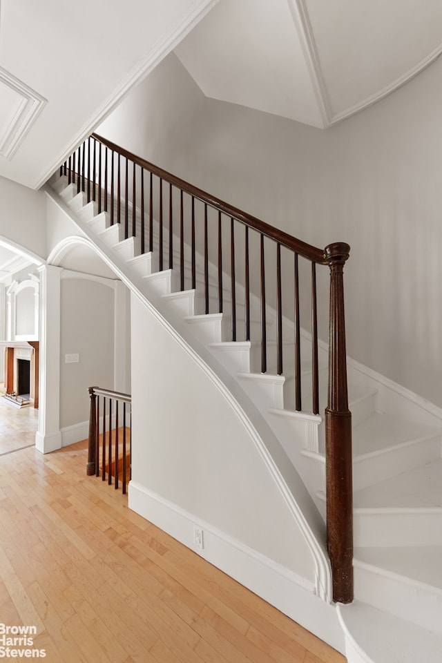 staircase featuring wood finished floors and baseboards