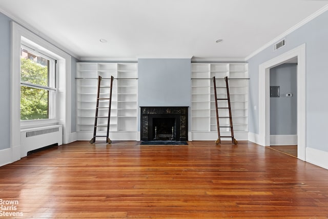 unfurnished living room featuring visible vents, crown molding, a fireplace, radiator heating unit, and hardwood / wood-style floors