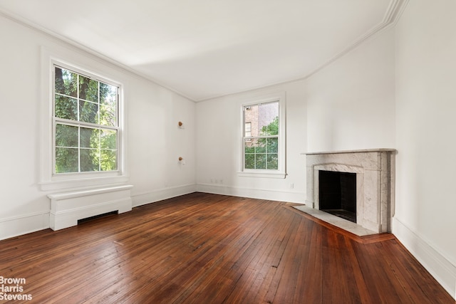 unfurnished living room with a premium fireplace, baseboards, hardwood / wood-style floors, and crown molding