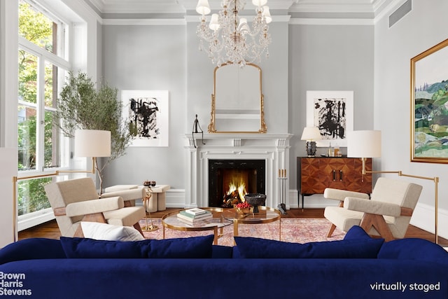 living room with wood finished floors, ornamental molding, a chandelier, and visible vents