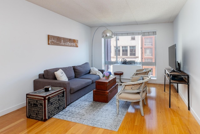 living area with baseboards and wood finished floors