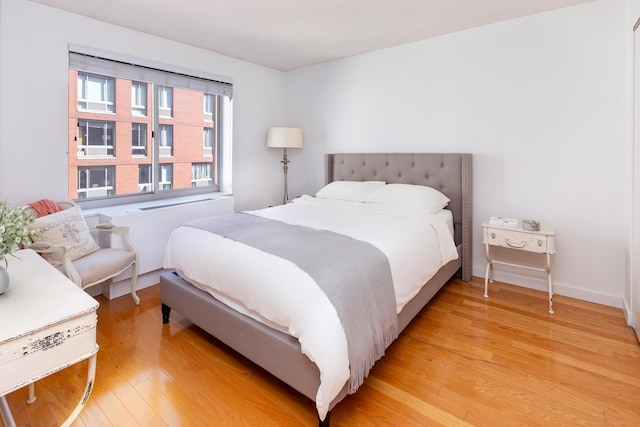 bedroom with light wood-type flooring and baseboards