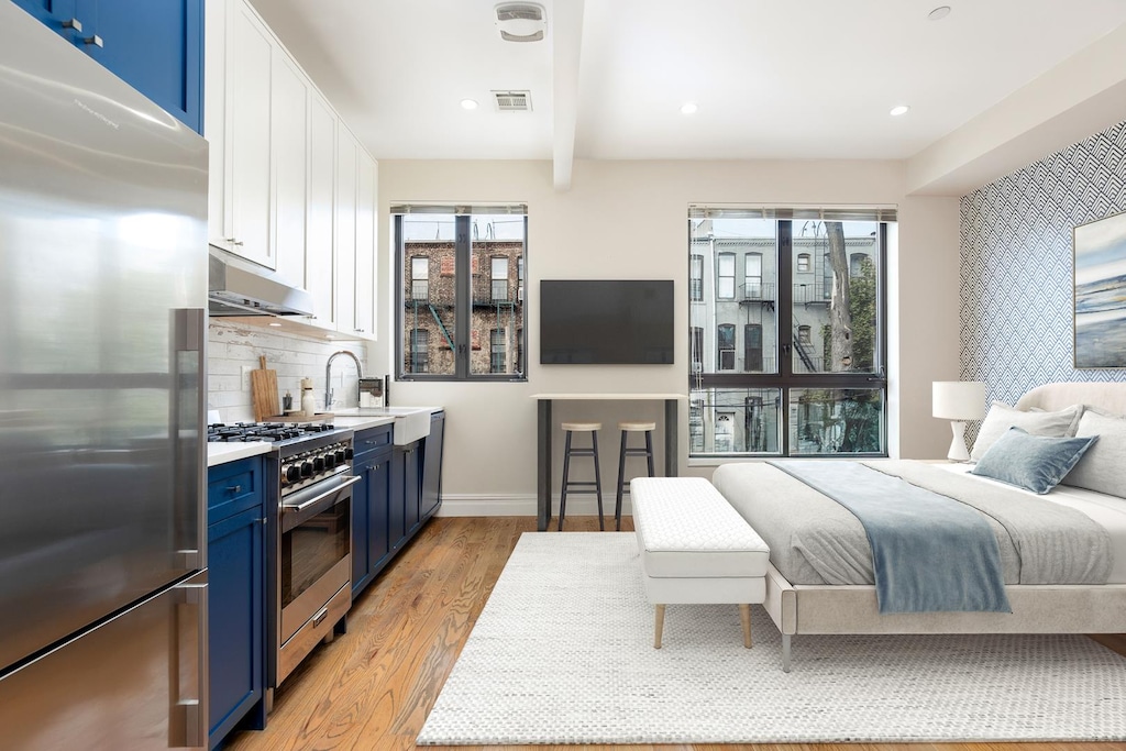 bedroom with high quality fridge, recessed lighting, visible vents, baseboards, and light wood-style floors