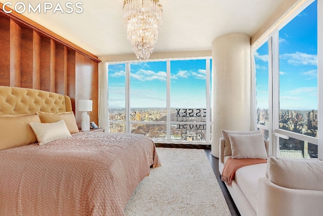 bedroom with a chandelier, floor to ceiling windows, and multiple windows