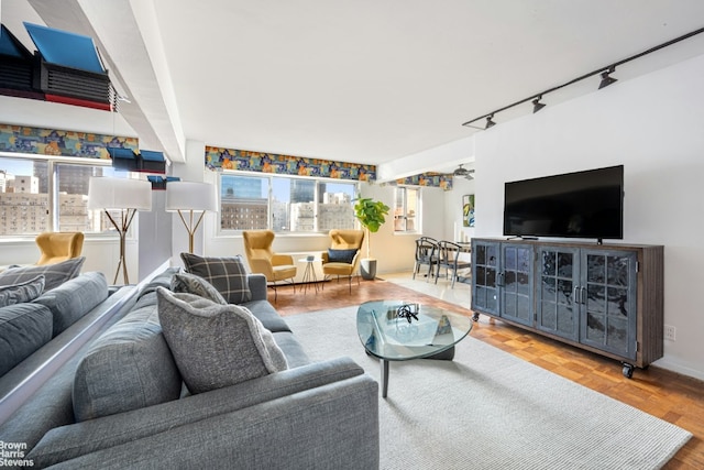 living room featuring ceiling fan, rail lighting, and parquet flooring