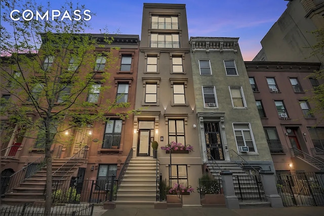 property at dusk with a fenced front yard