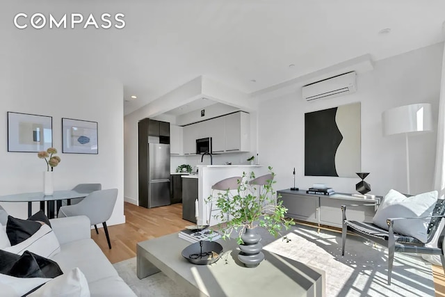 living area featuring recessed lighting, a wall mounted AC, and light wood-style floors