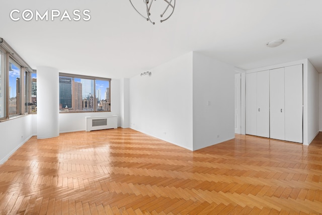 unfurnished living room with radiator heating unit and a view of city