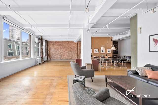 interior space with radiator heating unit, light wood-style floors, and brick wall