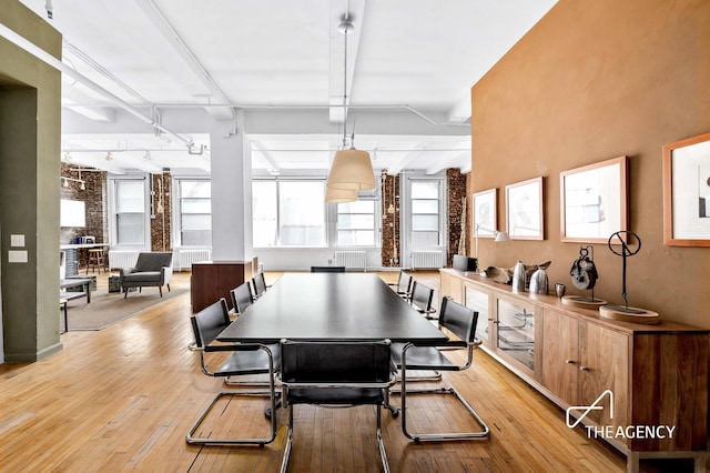 dining space with light wood-type flooring and rail lighting