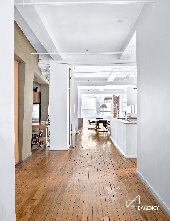 hallway featuring light wood-type flooring and baseboards