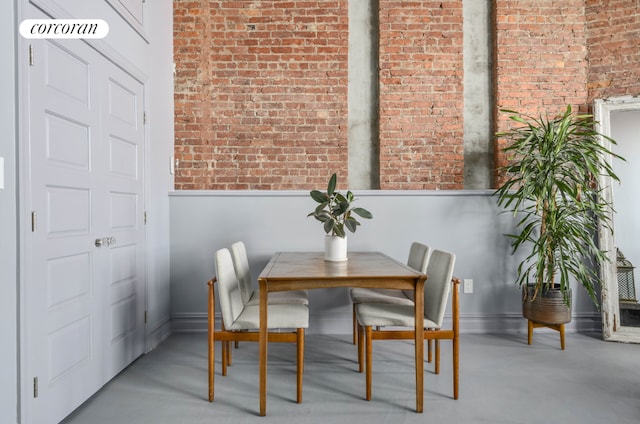 dining area featuring brick wall