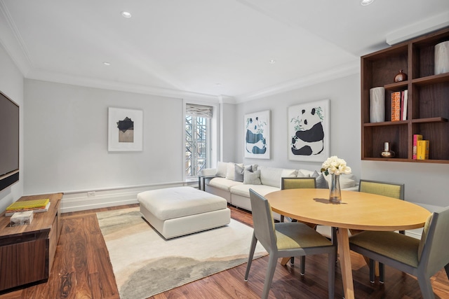 living area with ornamental molding, wood finished floors, and recessed lighting
