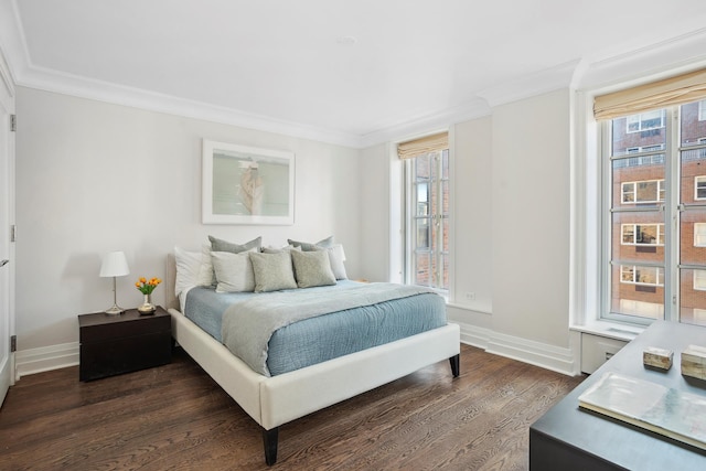 bedroom featuring dark wood-style floors, baseboards, and crown molding