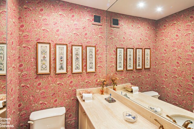 425 E 58th St Unit 14D, New York City, NY 10022 - bathroom with toilet, vanity, and wallpapered walls