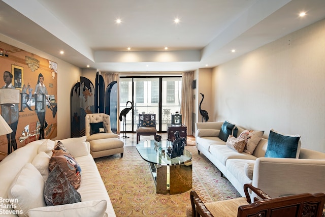 living area featuring recessed lighting and a raised ceiling