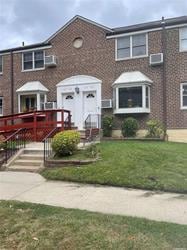 townhome / multi-family property featuring a front yard and a wall mounted AC