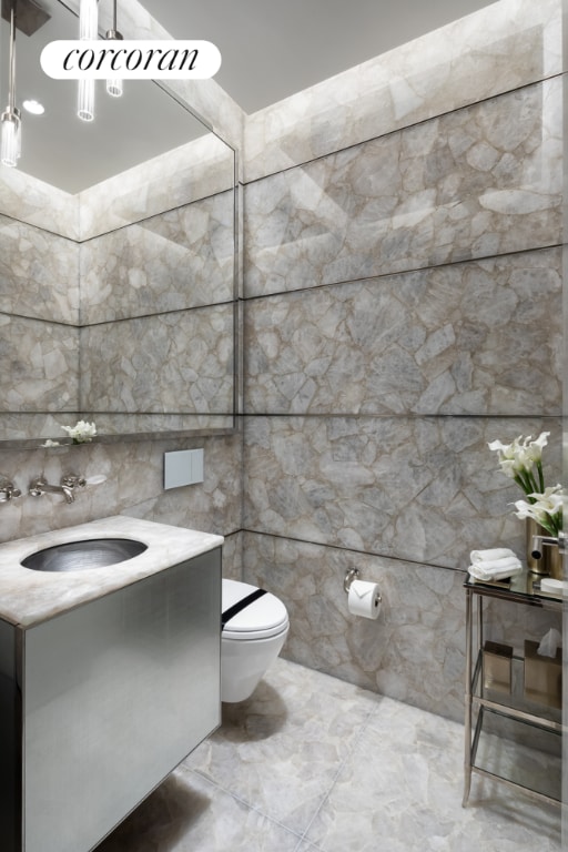 bathroom featuring tile walls, toilet, and vanity