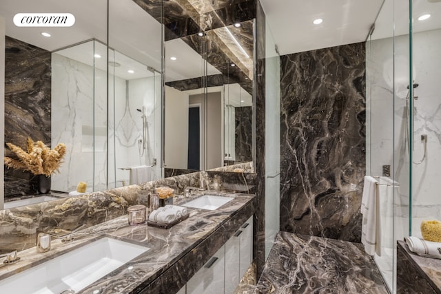 bathroom with vanity, tile walls, and a shower with door