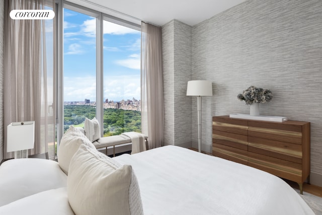 bedroom with a wall of windows and multiple windows