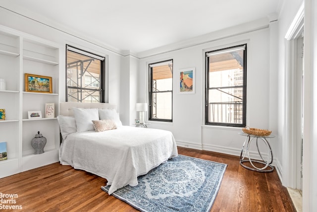 bedroom with hardwood / wood-style flooring and multiple windows