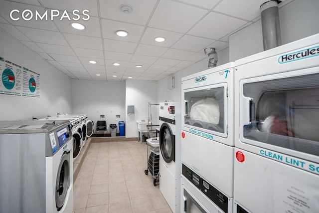 laundry room featuring washer and dryer, light tile patterned flooring, and stacked washer / drying machine