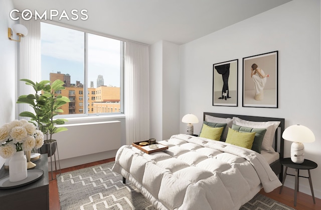 bedroom with a city view and wood finished floors