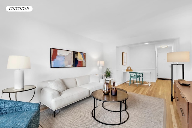 living area featuring visible vents, light wood-style flooring, and baseboards