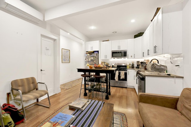 kitchen featuring tasteful backsplash, light wood-style flooring, white cabinetry, and stainless steel appliances