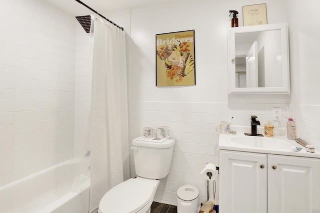 full bathroom with tile walls, toilet, wainscoting, shower / tub combo, and vanity