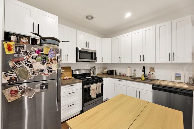 kitchen featuring tasteful backsplash, white cabinetry, appliances with stainless steel finishes, and sink