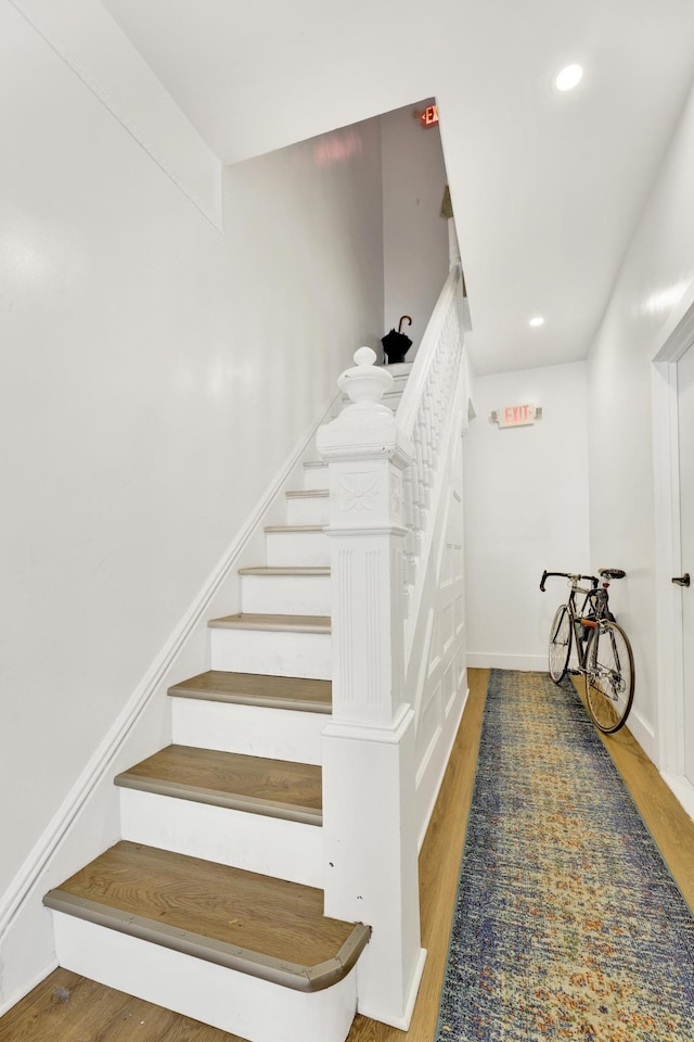 stairway featuring recessed lighting, baseboards, and wood finished floors