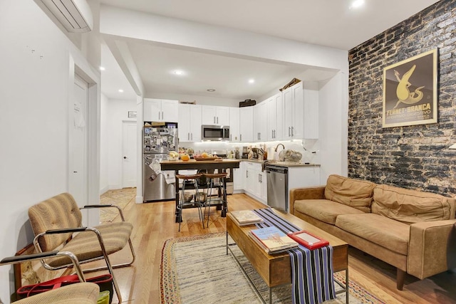 living room featuring bar, a wall unit AC, and light wood-type flooring