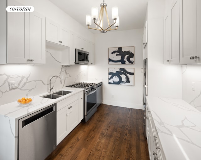 kitchen featuring hanging light fixtures, white cabinets, sink, and stainless steel appliances