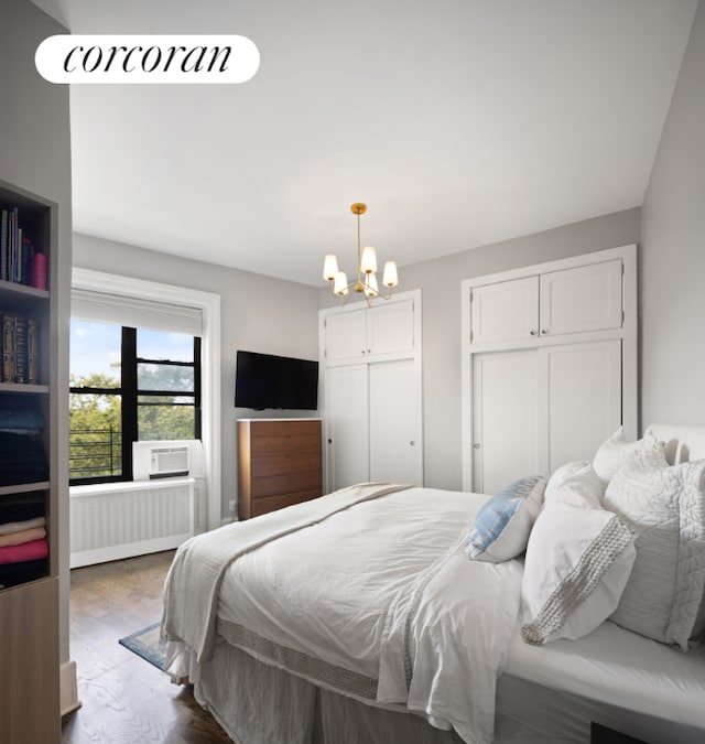 bedroom with a notable chandelier, wood-type flooring, and radiator heating unit