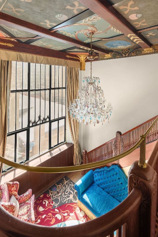 room details with coffered ceiling, beam ceiling, and a chandelier