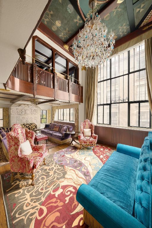 living area with a chandelier, wood-type flooring, and plenty of natural light