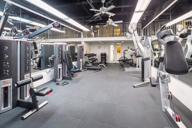 gym featuring ceiling fan and a towering ceiling