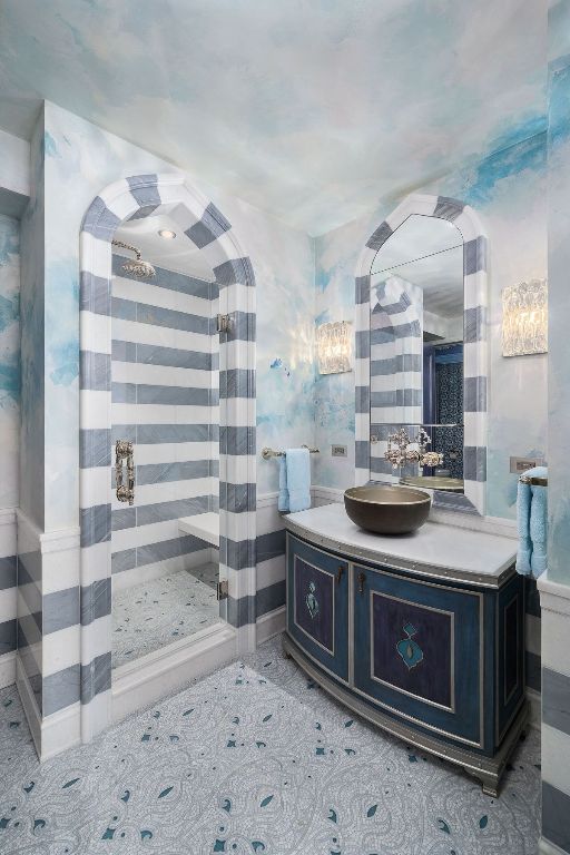 bathroom with vanity, a tile shower, and tile patterned floors