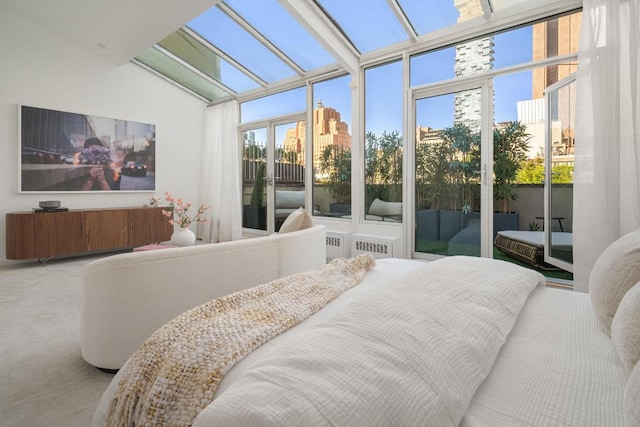 bedroom featuring lofted ceiling, carpet flooring, and multiple windows