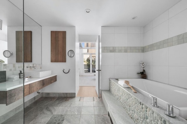 bathroom featuring vanity and tiled tub