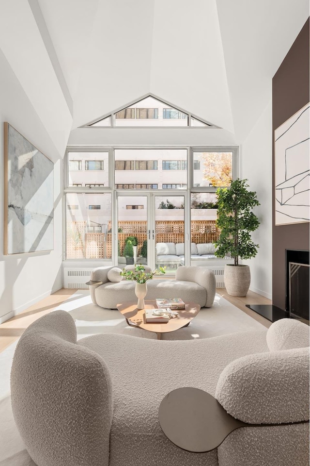 sunroom / solarium featuring a fireplace with raised hearth, lofted ceiling, and a wealth of natural light