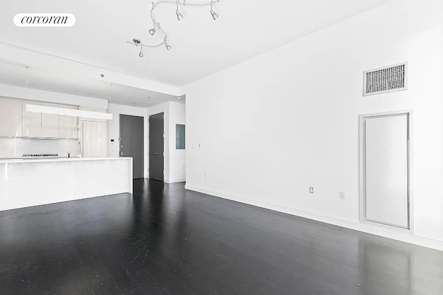 unfurnished living room featuring dark wood-style flooring, baseboards, and visible vents