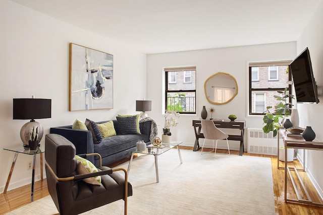 living room with radiator, wood finished floors, and baseboards