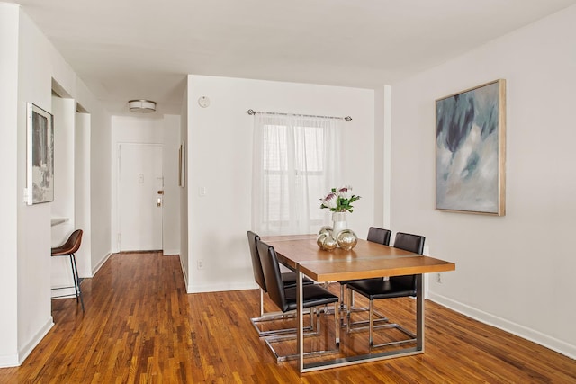 dining room featuring baseboards and wood finished floors